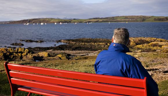 Man in blue jacket sitting on red bench, watching sailing boats on the Firth of Clyde. ©beckyduncanphotographyltd/SN. For information on reproduction rights contact the Scottish Natural Heritage Image Library on Tel. 01738 444177 or www.nature.scot Thumbnail